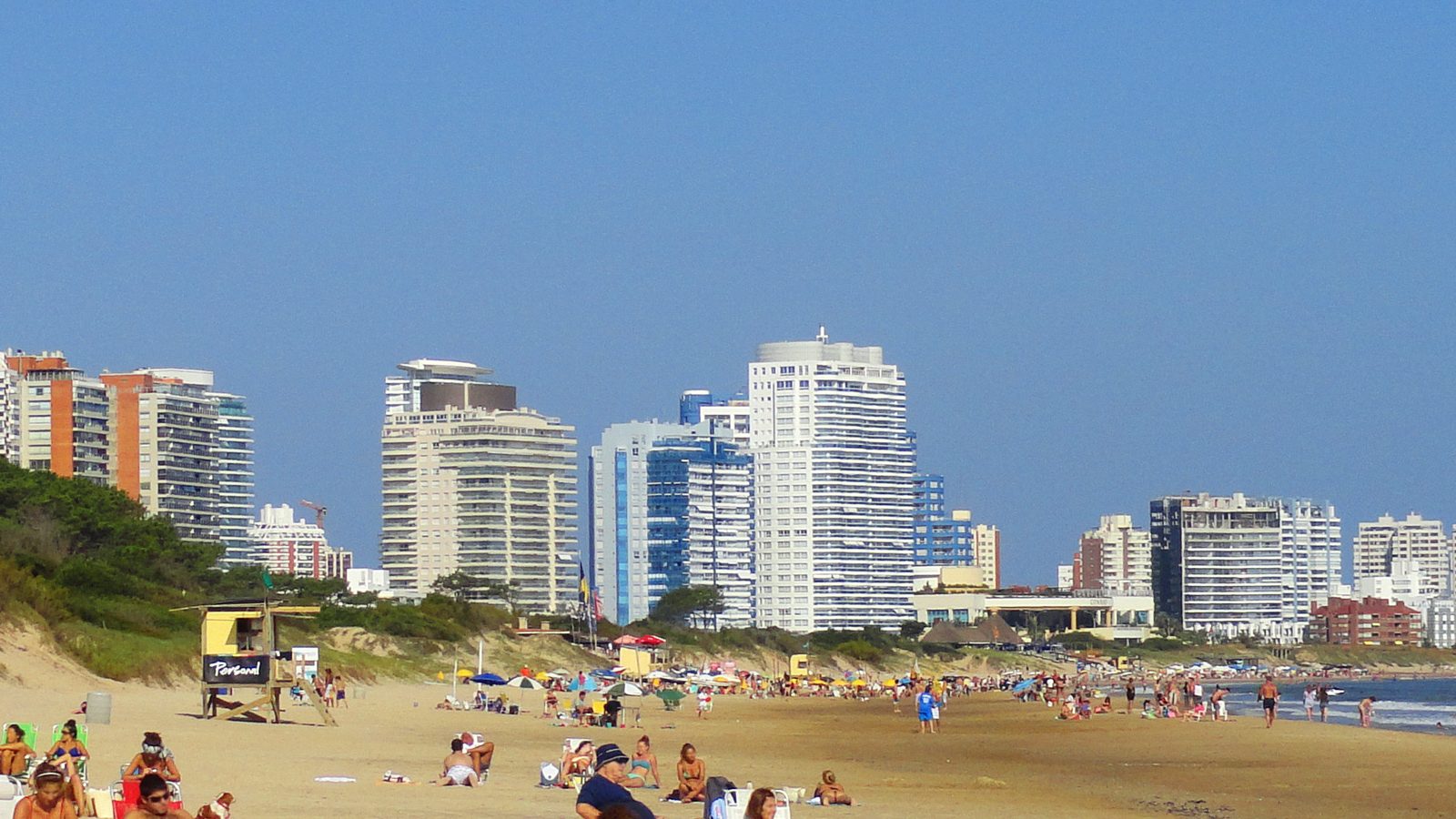 Real view of Playa Mansa, beachgoers and Punta del Este skyline