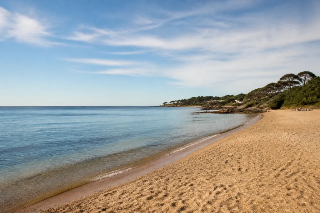 Coarse sand and calm-looking water at Pinares near Punta del Este